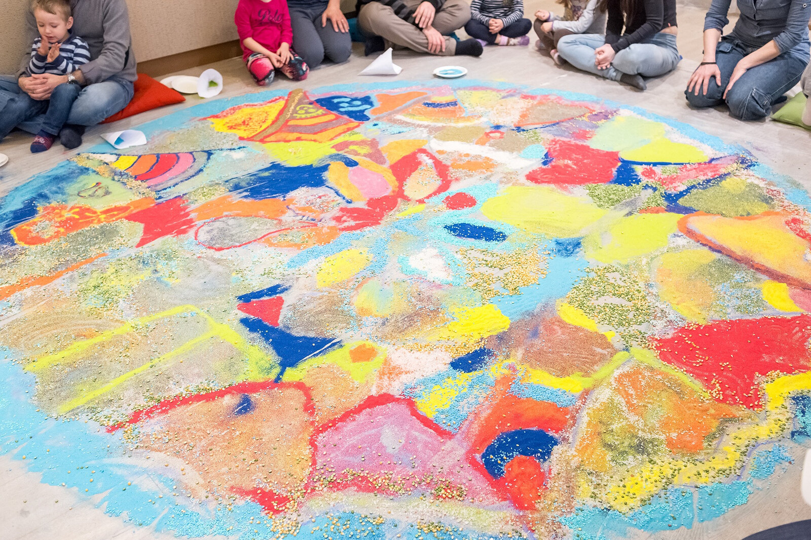 Bambini intorno a una grande opera pittorica creata insieme nell’atelier Tomorò
